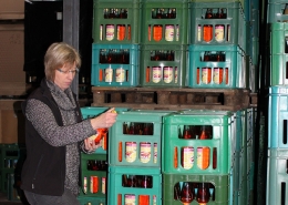 Süßmostkelterei Lammersiek, Frau Lammersiek begutachtet Flasche mit Direktsaft