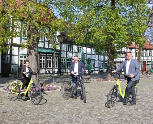 Eine Frau und zwei Männer stehend mit Fahrrädern